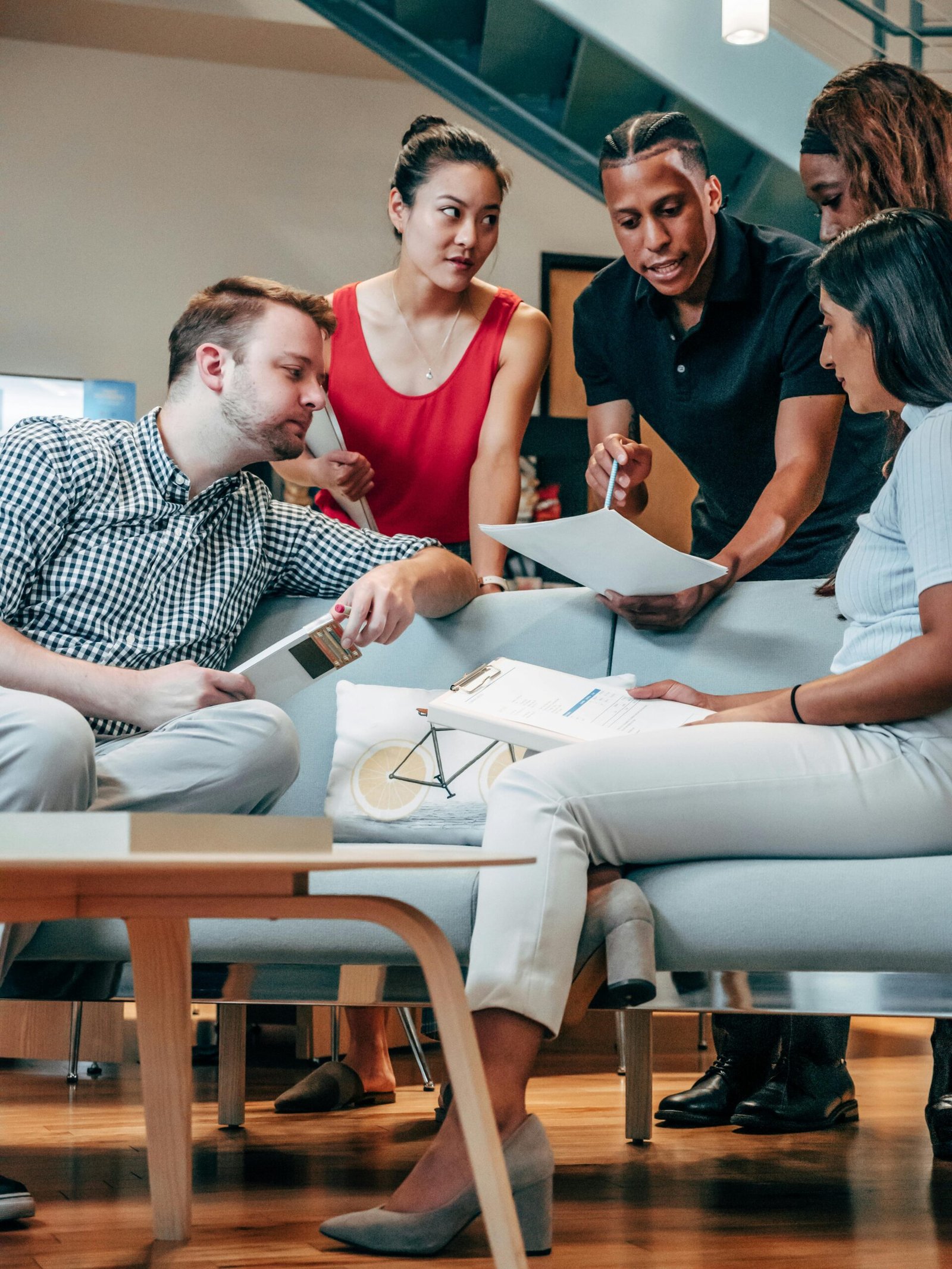 A diverse group of colleagues discusses ideas in a modern office setting.